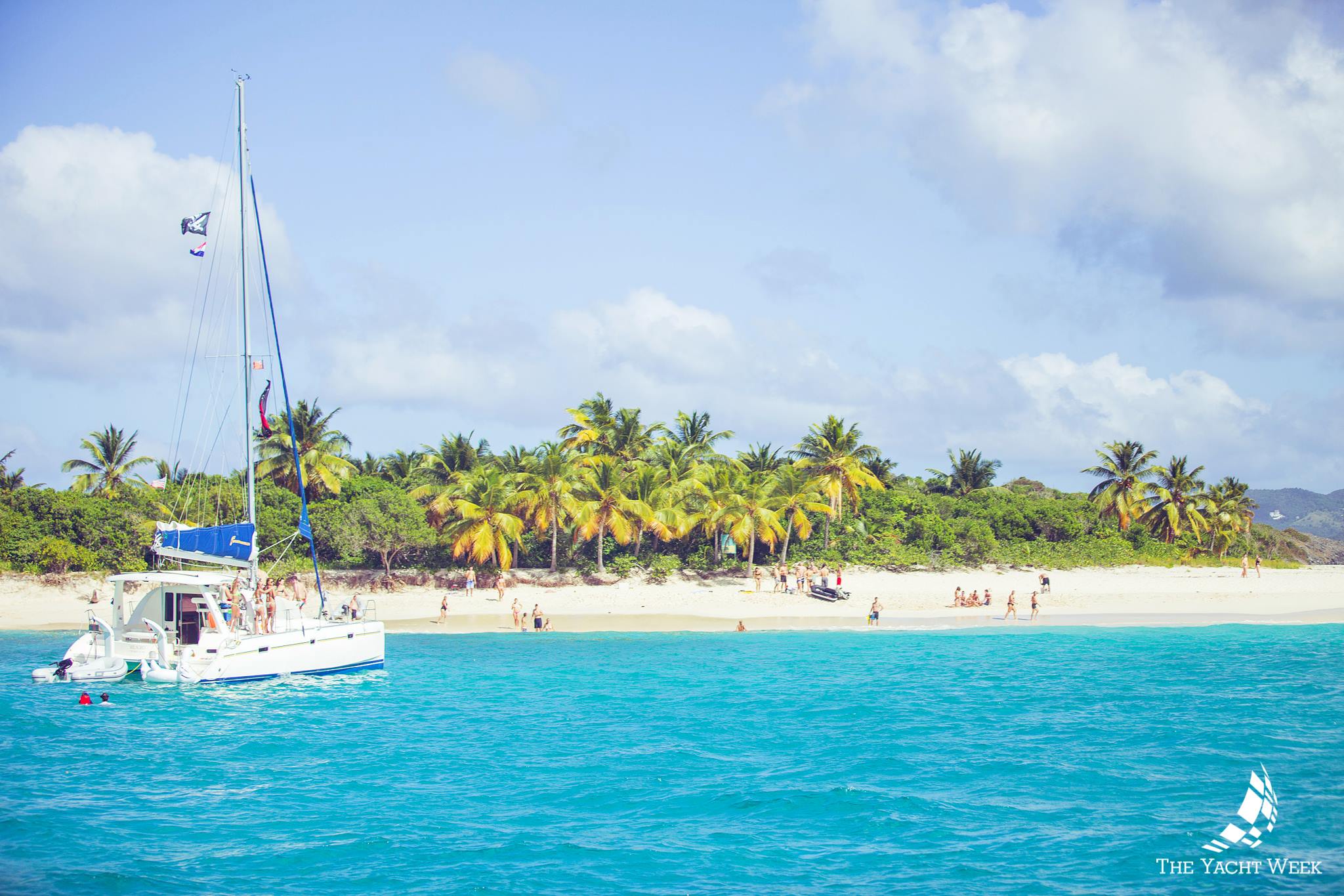 Catamaran in front on a white sand beach bvi